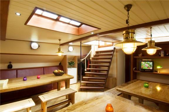 Salon der Gulden Belofte mit Holzesstischen und Sitzbänken