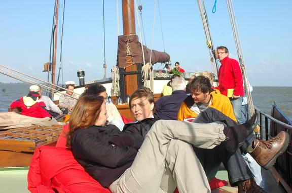 Gäste sitzen bei einem Tagesausflug an Deck der Gulden Belofte