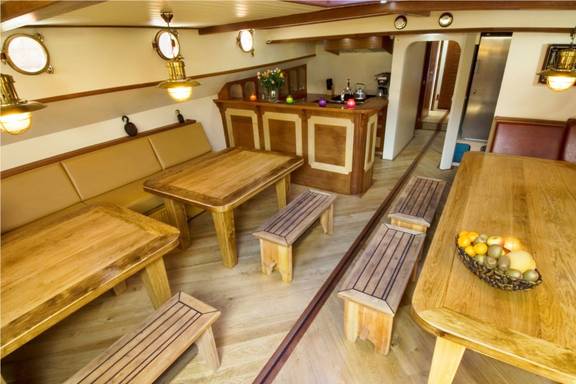 Salon der Gulden Belofte mit Holzesstischen und Sitzbänken