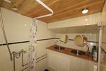 Badezimmer der De Lis mit Waschbecken und Dusche unter einer Holzdecke
