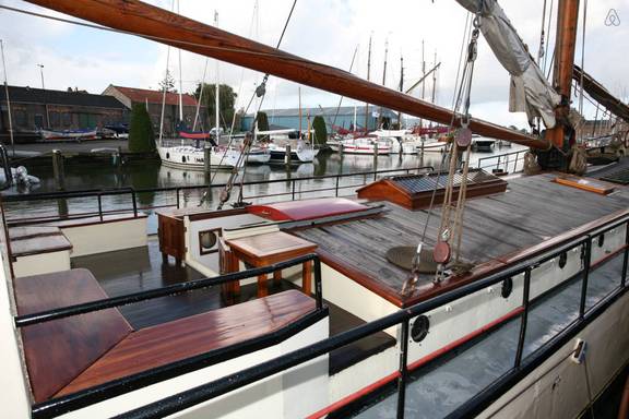 Sitzbänke und Holztisch an Deck der De Lis