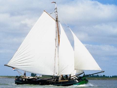 Tjalk Vrouwe Jitske unter weißen Segeln auf dem Wasser