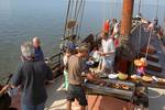 Gäste grillen an Deck der im Watt trockengefallenen Albatros