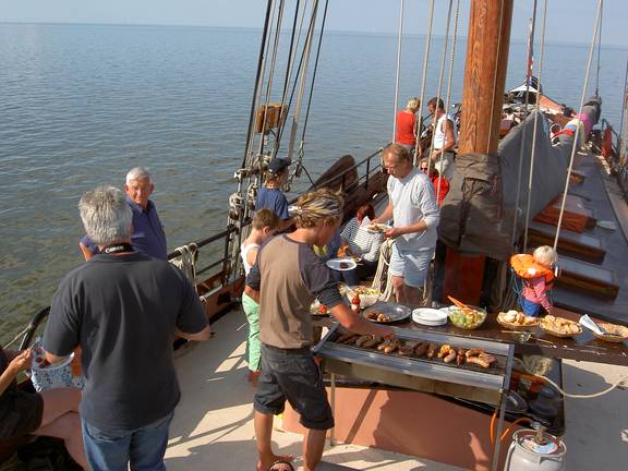 Gäste grillen an Deck der im Watt trockengefallenen Albatros