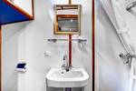 Badezimmer mit Dusche, Waschbecken und Spiegel auf der Mare fan Fryslân