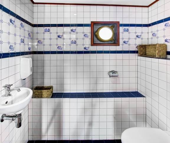 Toilette mit Waschbecken und blau-weißen Fliesen auf der Mare fan Fryslân