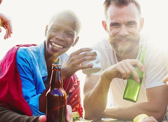 Freunde teilen Snacks und Getränke an einem Tisch im Freien