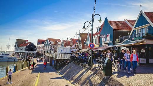 Spaziergänger auf dem Deich am Hafen von Volendam