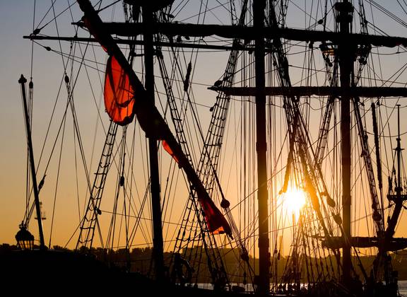 Masten und Takelage von Segelschiffen bei Sonnenuntergang